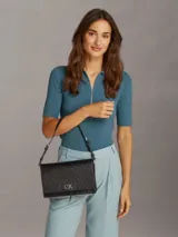Cartera de hombro Calvin Klein color negro con monograma CK en toda la superficie y logo metálico plateado en el frente.
