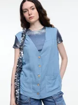 Chaleco celeste sin mangas con escote en V, cierre frontal con botones de madera y bolsillos delanteros.