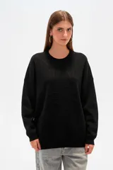 Sweater color crema, de corte holgado, con cuello redondo y mostacillas decorativas.