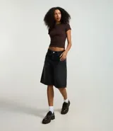 Remera negra de rib de algodón, con cuello redondo y mangas cortas. Corte ajustado y largo a la cadera.