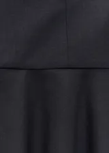 Minifalda negra de tejido mezcla de lana con bajo asimétrico y diseño evasé. Cierre cremallera invisible en el lateral.