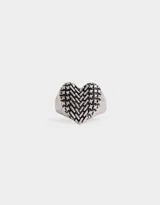 Anillo plateado con forma de corazón con textura entintada.