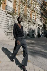 Jeans de tiro alto, corte recto y largo, color negro lavado, con abalorios brillantes distribuidos por toda la prenda.