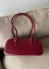 Cartera baguette de cuero sintético color borgoña con doble asa corta.