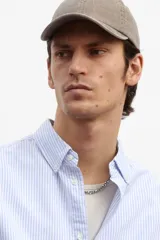 Camisa de vestir celeste y blanco a rayas verticales, de corte regular fit, con cuello abotonado, bolsillo en el pecho y mangas largas con puños abotonados.