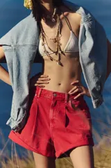 Short de jean rojo con tiro alto, corte relajado, diseño plisado, cierre de cremallera y botón, diseño de cinco bolsillos y dobladillos con puños.