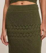 Pollera recta long midi color verde militar, con cintura elástica y confeccionada en tejido de punto con mix de puntos.