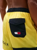 Short de baño amarillo de Tommy Hilfiger, con cintura elástica negra, cordón blanco y logo de la marca en la pierna izquierda.