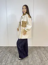 Sobre camisa color natural y camel, de corte holgado y manga larga.