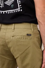 Bermuda de gabardina color verde oliva, con bolsillos laterales y traseros. Cierre frontal con botón y cremallera.