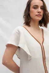 Vestido midi azul de lino con escote en V, mangas cortas con volados, bolsillos laterales y corte amplio. Presenta cintas verticales a contratono en el frente.