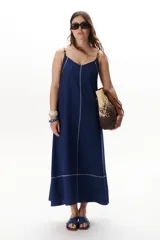 Vestido largo color crudo con breteles finos y costuras a la vista en color azul.