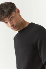 Sweater negro de punto con cuello redondo y textura acanalada.