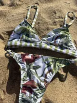 Conjunto de bikini blanco con estampado de manchas negras. El corpiño es de triángulo fijo con tirantes finos y la bombacha es tipo less regulable.