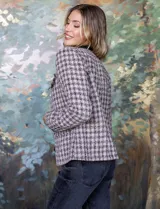 Chaqueta corta de tweed con lurex, cuello a la base y abertura central. Delantera con bolsillos simulados y forro interno.