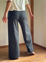 Pantalón palazzo color marrón claro, confeccionado en lycra de algodón, con tiro alto, bolsillos laterales y faja ancha en la cintura.