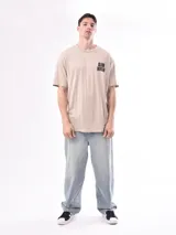 Remera beige de corte recto con estampado 'Aim High' en el pecho.