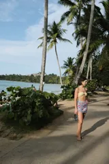 Pareo rectangular con estampado a cuadros en tonos celeste, naranja y blanco, con detalle de flecos en los bordes.