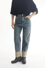 Pantalón de jean celeste con corte recto, tiro alto y dobladillo en color beige.