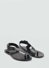 Sandalias negras de cuero con tira cruzada y hebilla dorada.