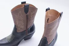 Bota texana de cuero negro con bordados en el lateral y taco bajo.