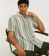 Camisa de hombre de algodón con rayas verticales en tonos gris y blanco, cuello inglés, manga corta y cierre abotonado.
