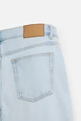 Pantalón de jean gris de corte recto, con cinco bolsillos, efecto lavado y cierre frontal con botones.