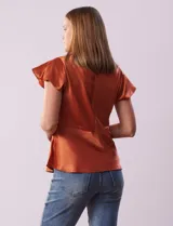 Blusa color naranja óxido de satén, marca Alex & Lili. Manga corta amplia con volados. Corte bajo el busto. Espalda con abertura ojal y botón.