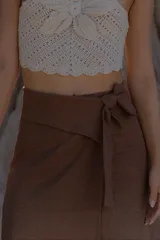 Pollera marrón de corte midi, con diseño cruzado y lazo lateral.