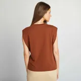 Camiseta marrón sin mangas con hombreras.