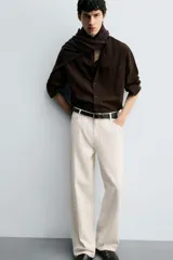 Pantalón de jean color crudo con textura de rayas verticales, corte relaxed fit, tiro medio, cinco bolsillos y cierre frontal con cremallera y botón.