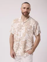 Camisa de hombre de manga corta con cuello cubano y estampado de hojas en tonos beige y blanco.