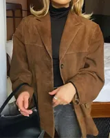 Blazer marrón de gamuza con solapas de muesca, cierre con dos botones y bolsillos con solapa.