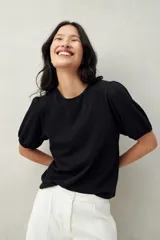 Remera negra de algodón con mangas abullonadas y elástico en la terminación.