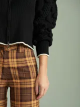 Cardigan marrón de tejido de punto con cierre frontal, cuello redondo y mangas abullonadas con apliques de pompones.