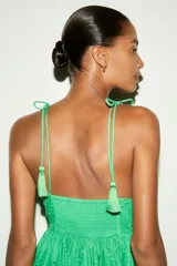 Vestido largo verde con breteles finos y escote en V. Presenta bordados florales y detalles de broderie en todo el vestido. Tiene corte en la cintura y falda con vuelo.