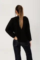 Camisa negra de estilo bohemio romántico, confeccionada en algodón con lino. Es un modelo de corte flojo y mangas estilo murciélago. Presenta volados en el escote y cierre frontal con botones.