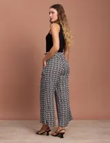 Pantalón capri estampado con flores en tonos celeste, blanco y negro. Tiene pretina elastizada en la parte trasera y bolsillos delanteros.
