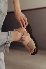 Sandalias de cuero color arena con base de goma negra, taco de 4cm y plataforma delantera de 1,5cm.