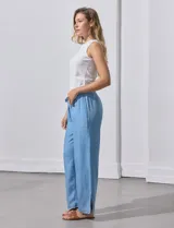 Pantalón ancho de lyocell color celeste, con cintura elástica ajustable con cordón y aberturas laterales en el ruedo con detalle de flecos.