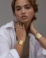 Brazalete ancho de bronce macizo con textura irregular.