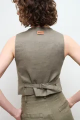 Chaleco sastre color amarillo mostaza, confeccionado en lino con forro de algodón y cierre frontal con botones.