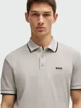 Polo blanca de algodón piqué de la marca Boss, con cuello clásico, tapeta de dos botones y logo bordado en el pecho. Detalles en negro en cuello y mangas.