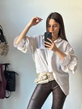 Camisa celeste a rayas blancas con mangas abullonadas y nudo en la parte delantera.