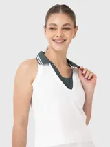 Top deportivo blanco con cuello polo y ribete verde oscuro.