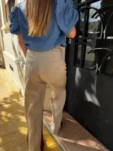 Pantalón sastrero color beige de lino, corte recto y tiro alto, con bordado de caballo en el bolsillo trasero.