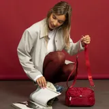 Bandolera roja de nylon con bolsillo frontal con cierre, apertura superior con cierre y dos bolsillos internos. Incluye correa larga regulable y desmontable.