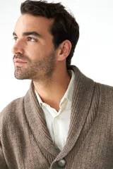 Cardigan tejido color marrón con cuello smoking, cierre con botones y bolsillos delanteros.