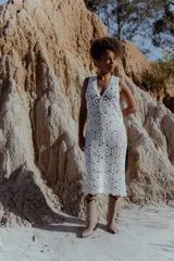 Chaleco largo calado color blanco, tejido al crochet, sin mangas y con caída fluida.