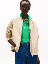 Campera bomber color beige, acolchada y repelente al agua, con cuello de béisbol, cierre frontal, puños y cuello de punto canalé, y dos bolsillos laterales ribeteados en diagonal.